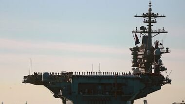 Sailors and Marines line the deck of aircraft carrier USS Abraham Lincoln (CVN-72) as it deploys from San Diego, Jan. 3, 2021.
