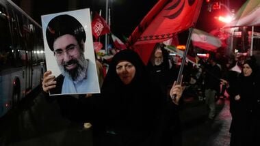 US-Iran War News LIVE: A woman holds up a poster of Iranian Supreme Leader Ayatollah Mojtaba Khamenei and waves a flag during a pro-government gathering at a square in Tehran, Iran, Tuesday, Aug. 11, 2026.