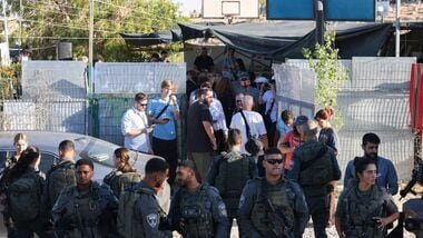 Latest news on August 7, 2026: Members of Israel's security forces stand as Palestinians, foreigners and israeli activists attend a memorial ceremony for slain Palestinian activist Awdah Hathaleen on the anniversary of his death Umm al-Khair village in the occupied West Bank city of Hebron on July 28, 2026.