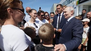 In this pool photograph distributed by the Russian state agency Sputnik, Russia's President Vladimir Putin interacts with local residents on Iturup island, one of four islands in the contested chain known as the Kuril Islands in Russia and the Northern Territories in Japan, on August 13, 2026. (Photo by Gavriil Grigorov / POOL / AFP)