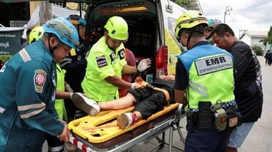 Emergency personnel assist an injured teacher near an ambulance at Debsirin Nonthaburi School, the site of a shooting incident, in Bang Kruai district in Nonthaburi province on the outskirts of Bangkok, Thailand, August 7, 2026.
