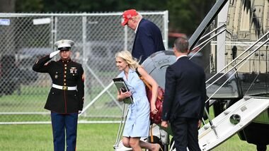 US President Donald Trump and aide Natalie Harp exit Marine One on the Ellipse near the White House on August 16, 2026. President Trump is returning to the White House after spending the weekend at his golf club in New Jersey. (Photo by Mandel NGAN / AFP)