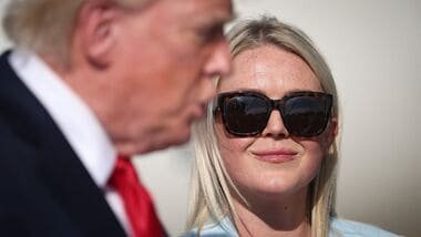 Press Secretary Karoline Leavitt listens as U.S. President Donald Trump speaks with reporters before boarding Air Force One on August 21, 2026 in Joint Base Andrews, Maryland.  Win McNamee/Getty Images/AFP