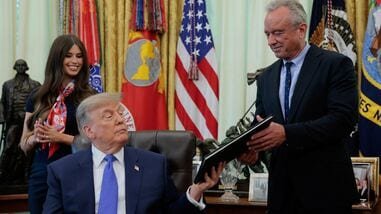 U.S. President Donald Trump hands over a signed executive order regarding vaccine flexibility to Secretary of Health and Human Services (HHS) Robert F. Kennedy Jr., in the Oval Office at the White House in Washington, D.C., U.S., August 10, 2026. REUTERS/Kylie Cooper