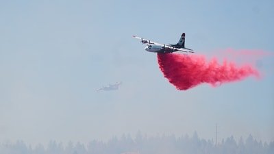 Representational image of fire retardant being dropped by air tanker onto a fire. (Skyler Geissler via AP)